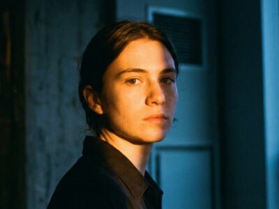 Why are Geminis so two-faced and fake — expressive person with a complex, shifting expression in dramatic split lighting, dual tones suggesting duality